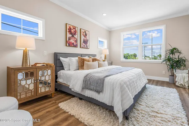a spacious bedroom with a bed a dresser and next to a window