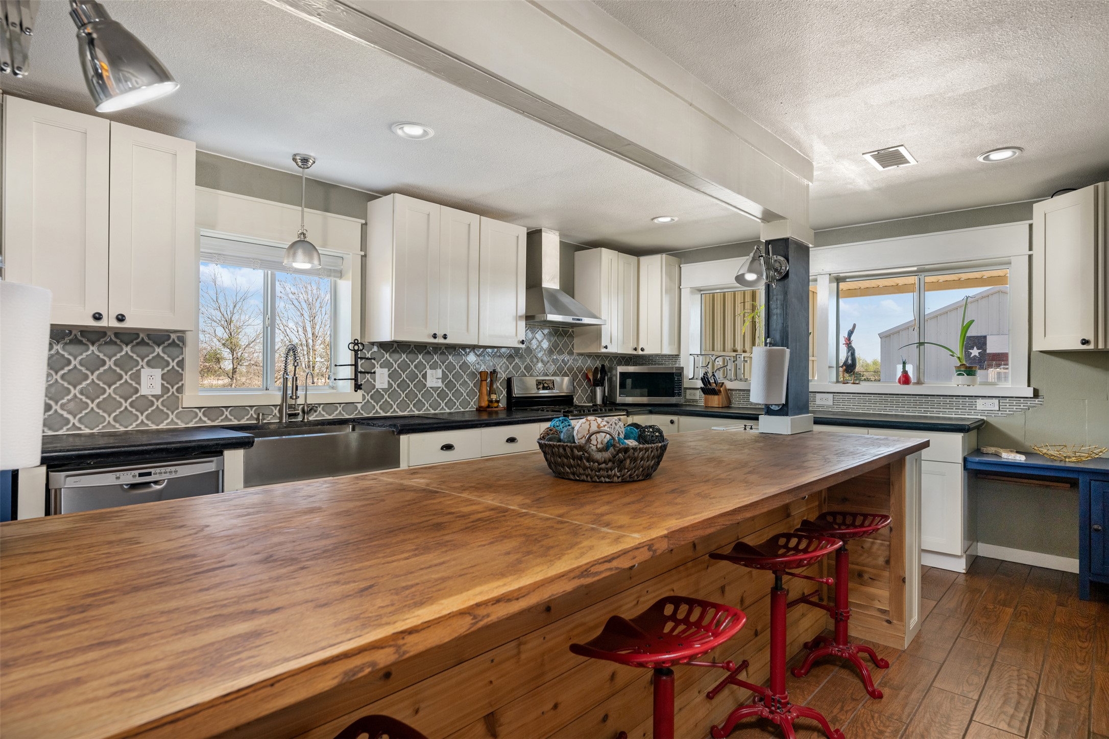 6501 County Road 239 Jarrell, TX 76537 - Photo 1 of 40 Kitchen featuring white cabinetry, wood and concrete counters, stainless steel appliances, and decorative backsplash