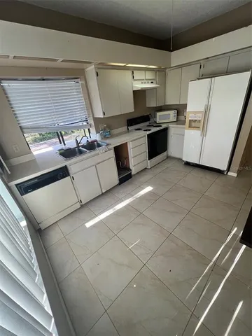 a kitchen with a sink and white cabinets