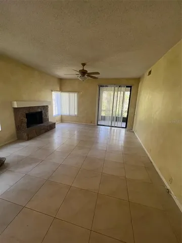 a view of an empty room with a fireplace and a window