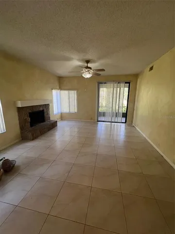 a view of an empty room with a fireplace and a window