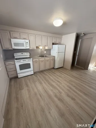 a view of a kitchen with wooden floor and electronic appliances