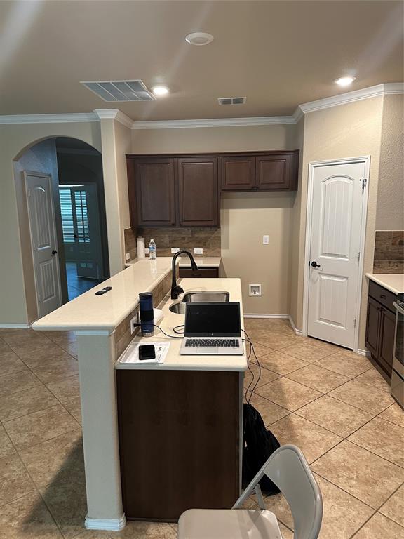 8404 Sioux Trail Aubrey, TX 76227 - Photo 17 of 20 a kitchen with kitchen island a stove a sink and a refrigerator