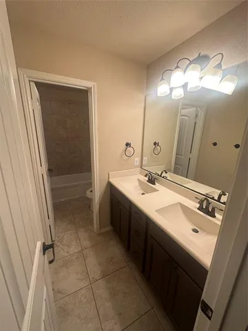 a spacious bathroom with a double vanity sink a mirror and a shower