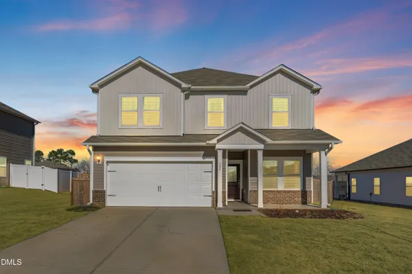 a front view of a house with a yard and garage
