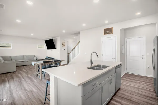 a kitchen with stainless steel appliances granite countertop a sink and a stove with wooden floor