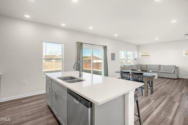 a kitchen with stainless steel appliances granite countertop a sink a stove and a wooden floors