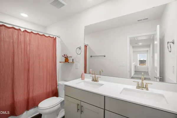 a bathroom with a granite countertop sink toilet and a mirror