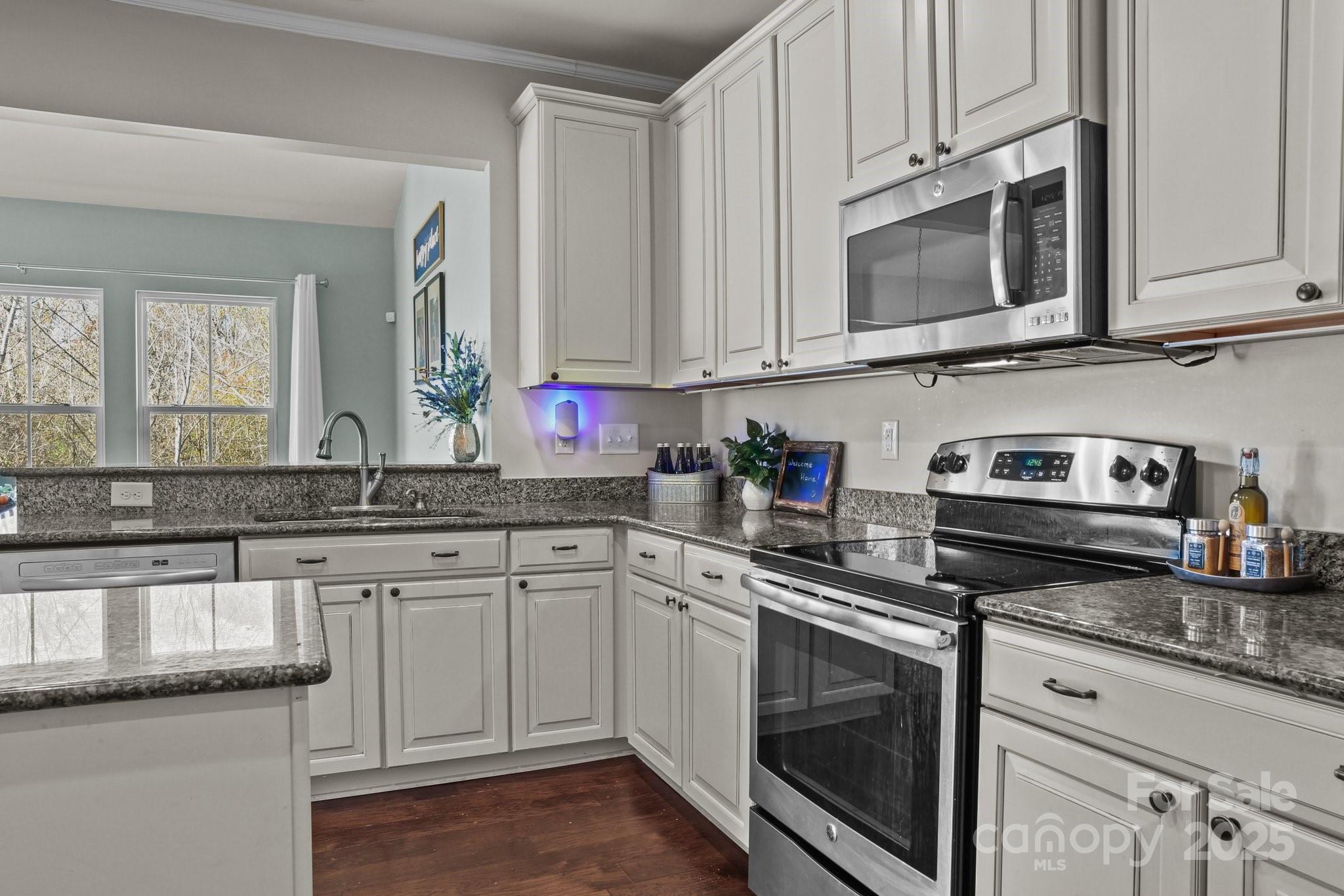 7520 West Berkeley Road Denver, NC 28037 - Photo 17 of 38 a kitchen with granite countertop white cabinets sink and stainless steel appliances