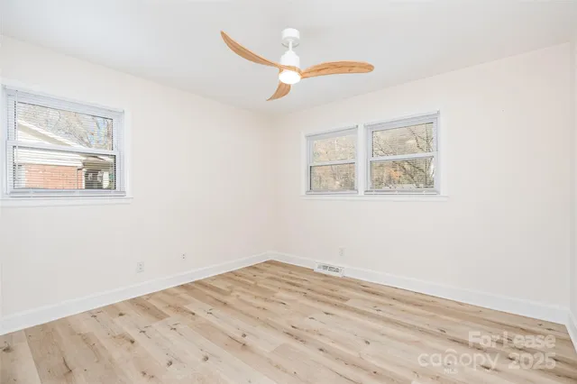 a view of a room with wooden floor and a window