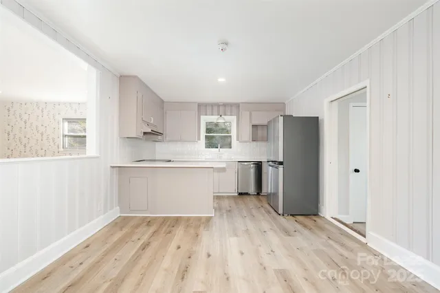a kitchen with a refrigerator sink and cabinets