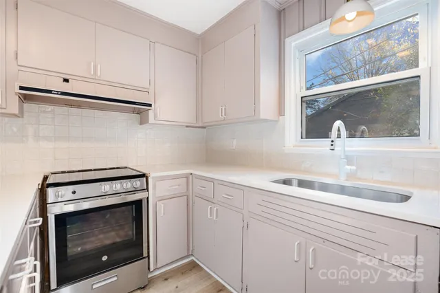 a kitchen with cabinets appliances a sink and a window