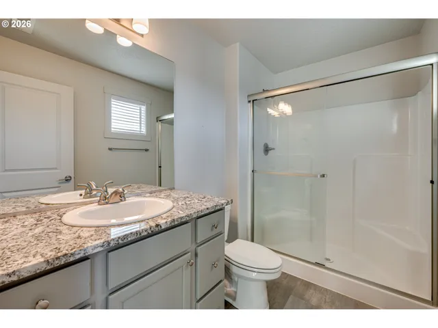 a bathroom with a granite countertop sink toilet a shower and a mirror