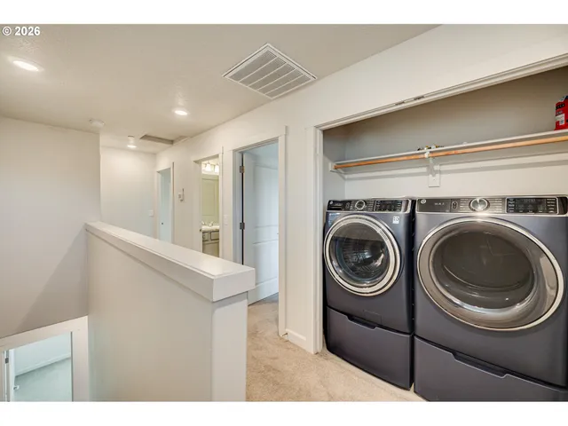 a backyard of a house with table and chairs under an umbrella with a small yard