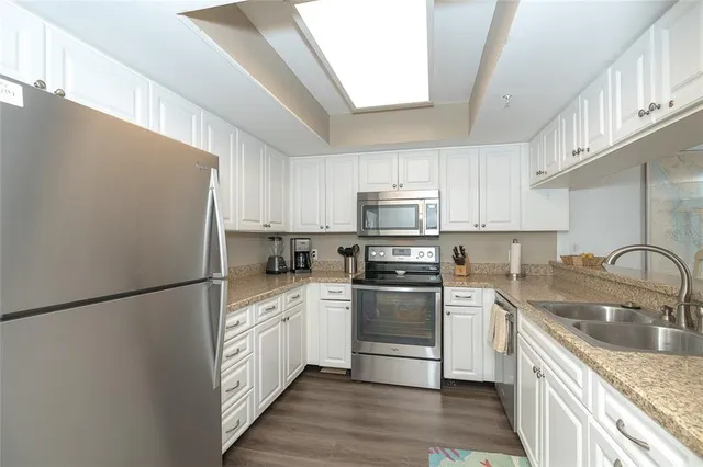 a kitchen with white cabinets and white appliances