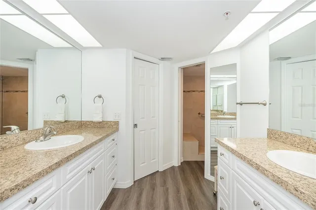 a spacious bathroom with a granite countertop sink and a mirror