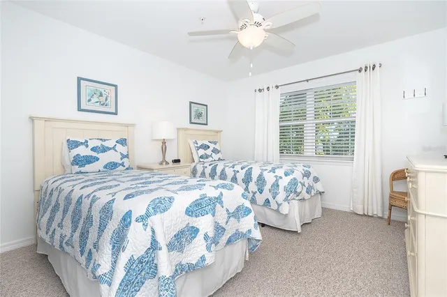 a bedroom with two beds and a large window