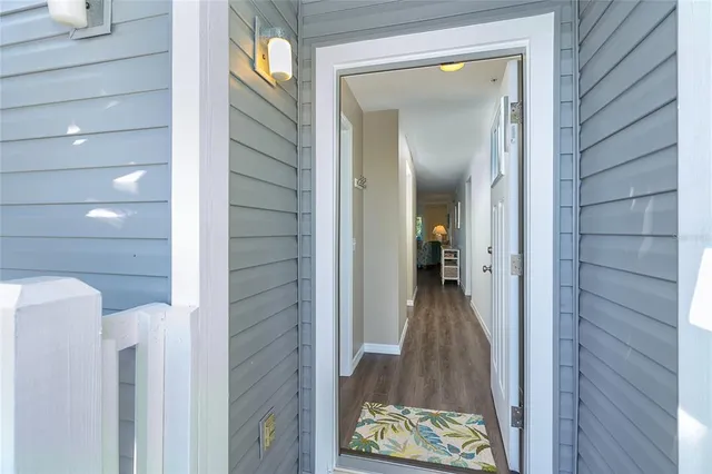 a view of a hallway with wooden floor and a bathroom