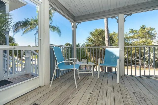 a view of a balcony with chairs and wooden floor