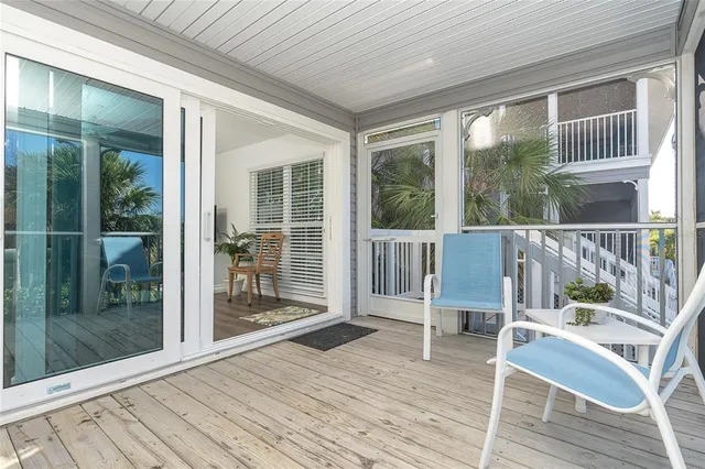 a view of a deck with table and chairs with wooden floor and floor to ceiling window
