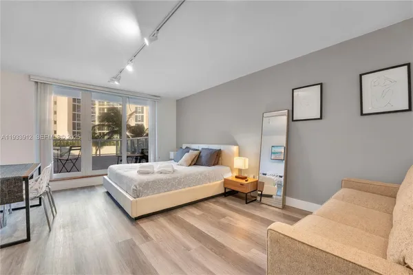 a spacious bedroom with a bed and a large window