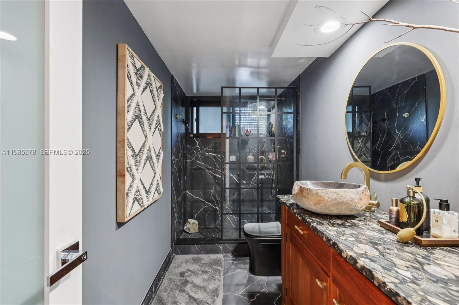 8375 Southwest 185th Terrace Cutler Bay, FL 33157 - Photo 11 of 35 a bathroom with a granite countertop toilet sink and mirror