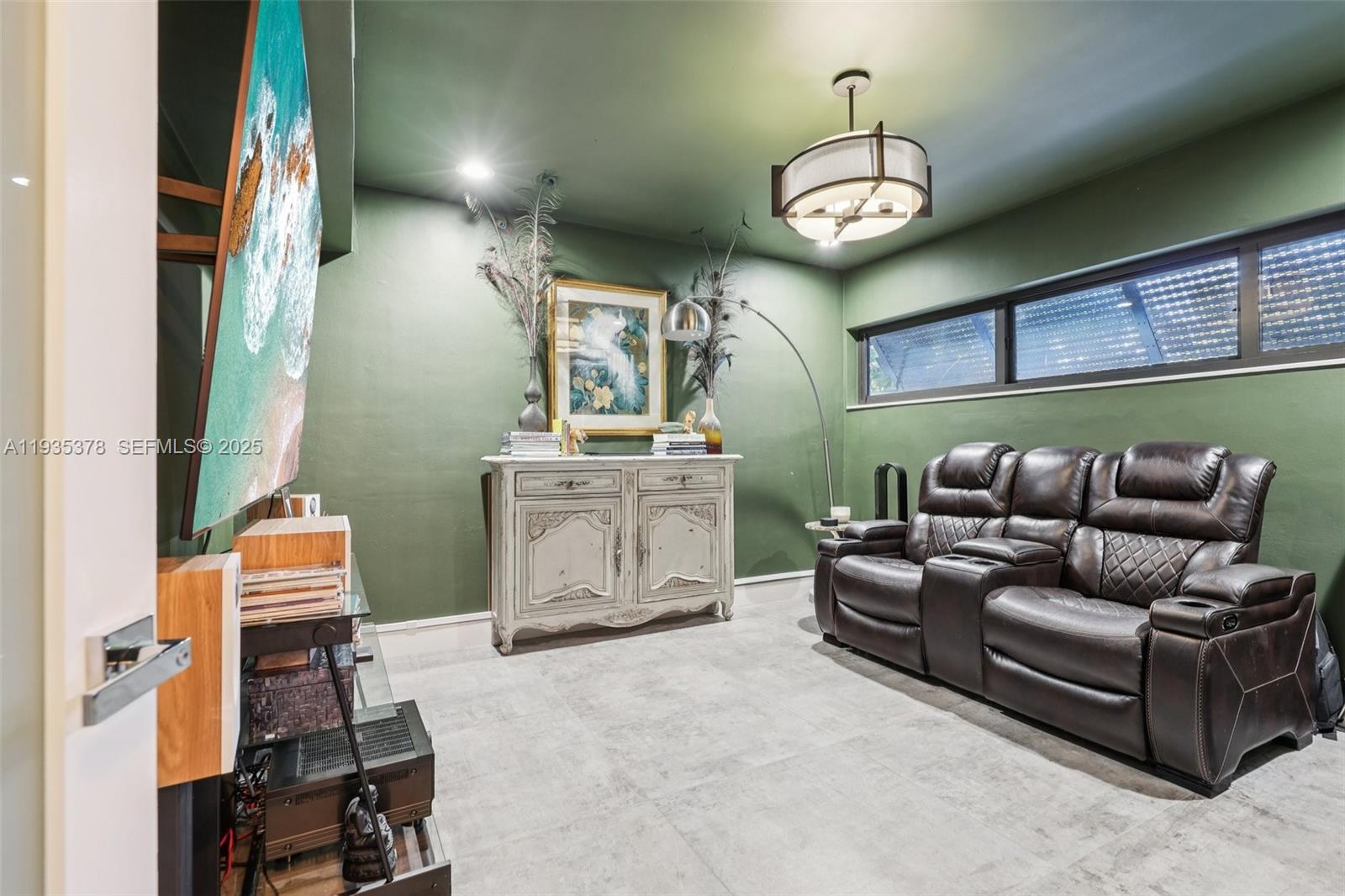 8375 Southwest 185th Terrace Cutler Bay, FL 33157 - Photo 10 of 35 a living room with furniture a chandelier and a window