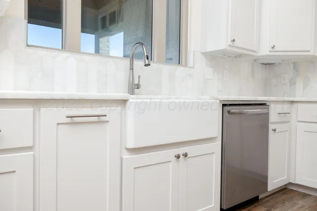 a view of a kitchen with white cabinets