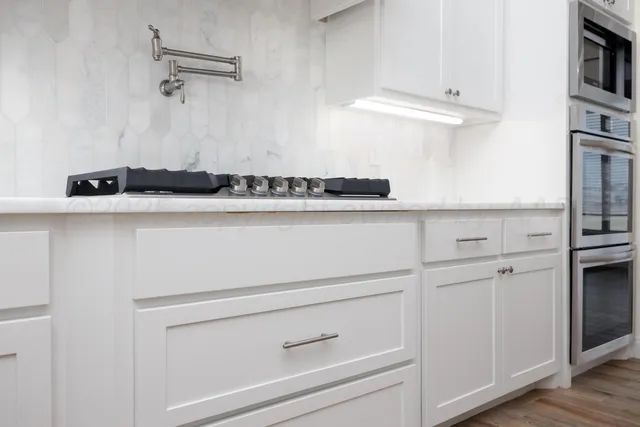 a kitchen with white cabinets and white appliances