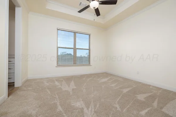 an empty room with a ceiling fan and windows
