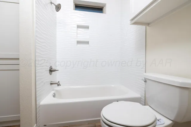 a white toilet and a bath tub sitting in a bathroom