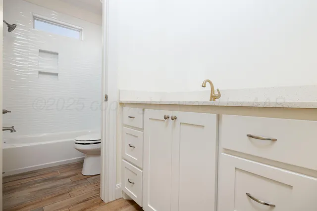 a bathroom with a sink a toilet and shower