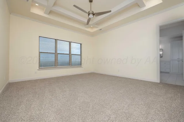 an empty room with windows and ceiling fan
