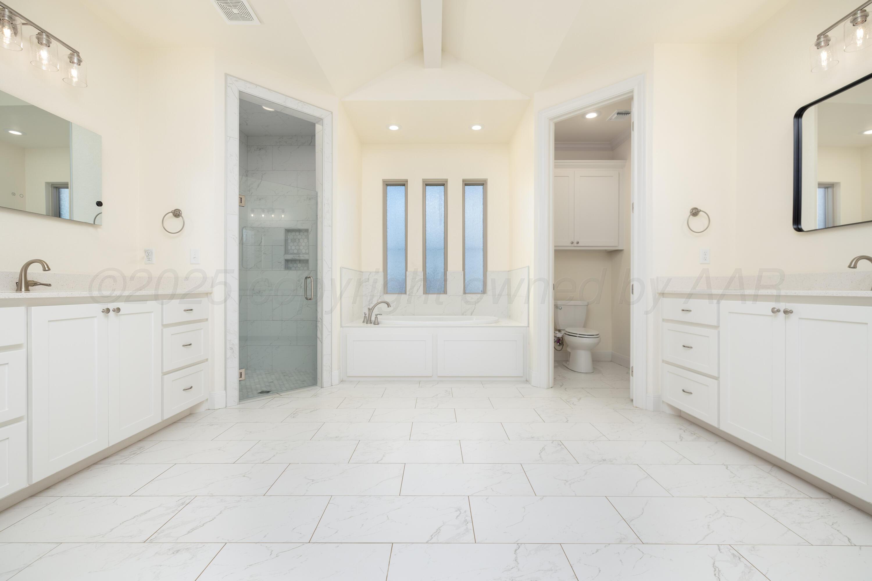 19350 Falcon Ridge Road Amarillo, TX 79124 - Photo 28 of 41 a bathroom with a vanity a sink a mirror and a bathtub