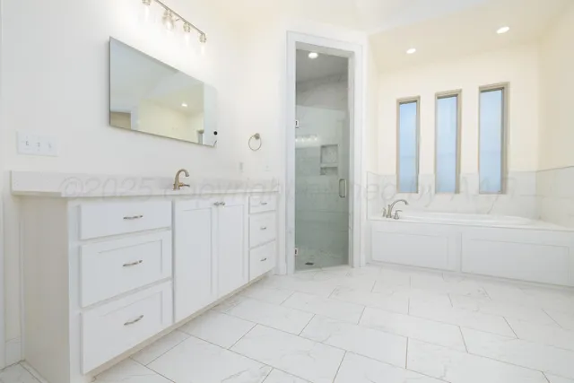 a bathroom with a tub sink and mirror