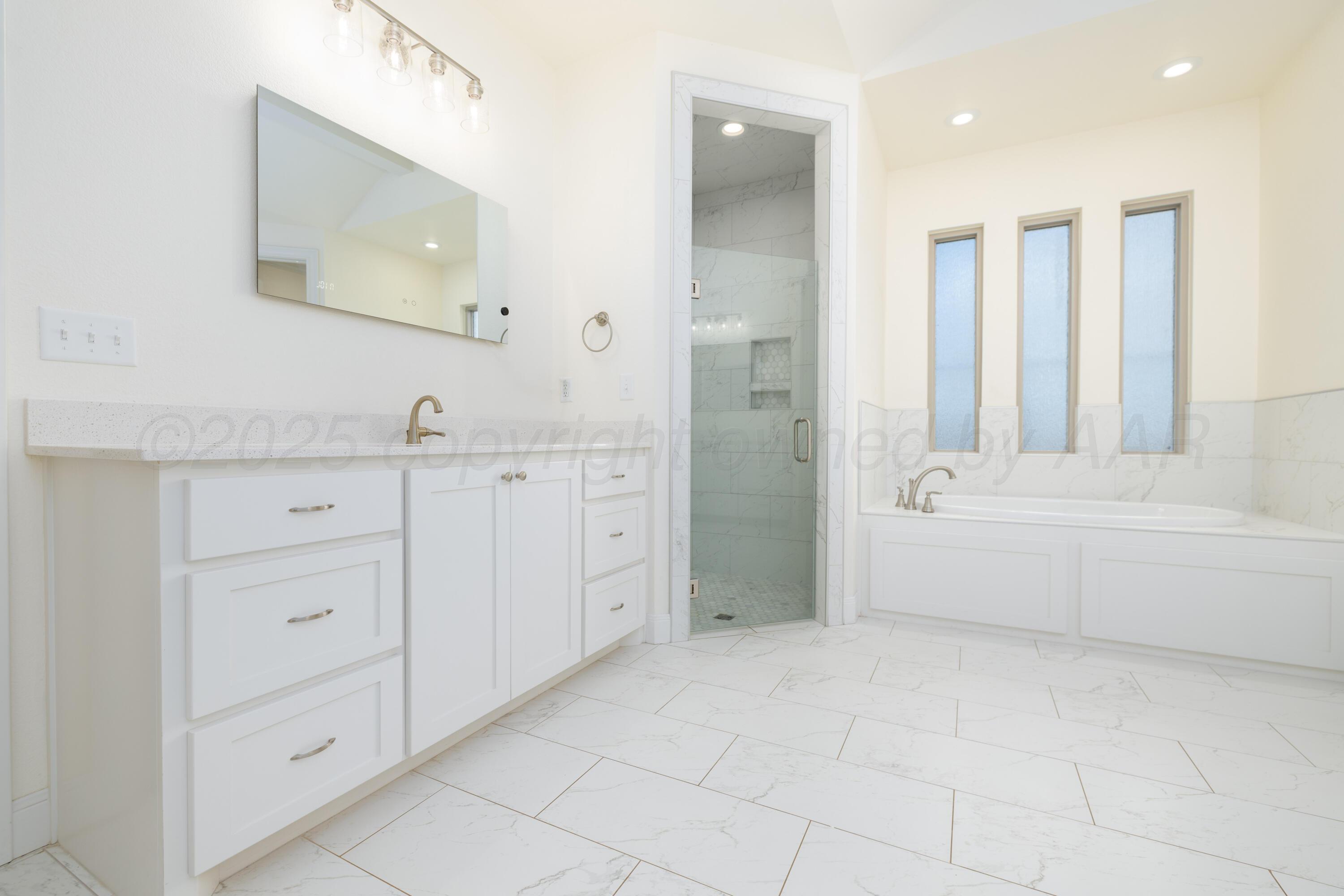 19350 Falcon Ridge Road Amarillo, TX 79124 - Photo 29 of 41 a bathroom with a tub sink and mirror