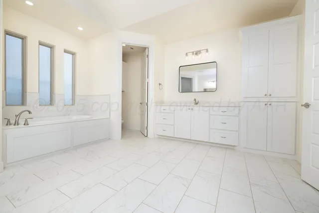 a bathroom with a bathtub sink and mirror