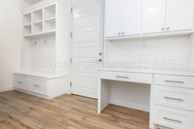 a view white cabinets and wooden floor