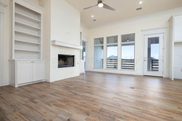 wooden floor fireplace and windows in an empty room