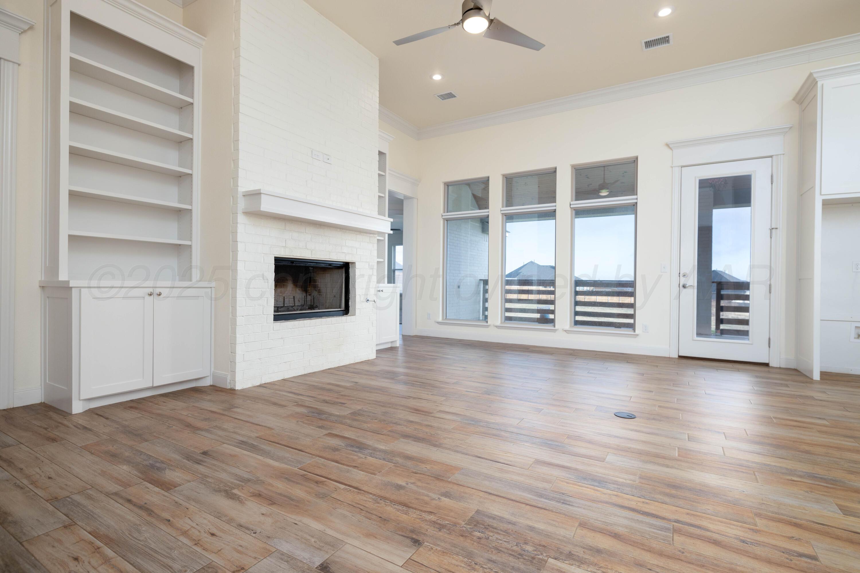 19350 Falcon Ridge Road Amarillo, TX 79124 - Photo 10 of 41 wooden floor fireplace and windows in an empty room
