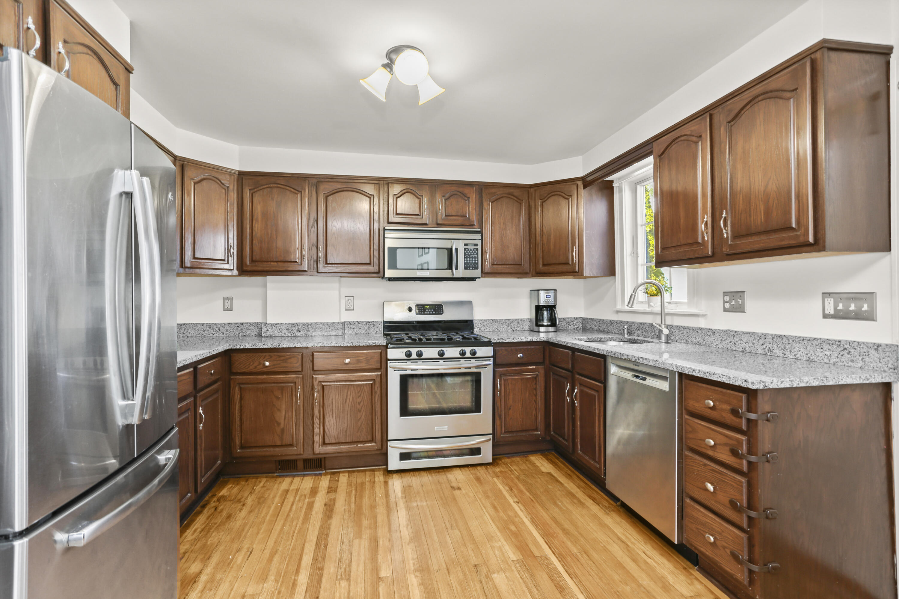5 Hazel Street Norwalk, CT 06851 - Photo 13 of 32 a kitchen with stainless steel appliances granite countertop wooden cabinets a stove top oven a sink and dishwasher