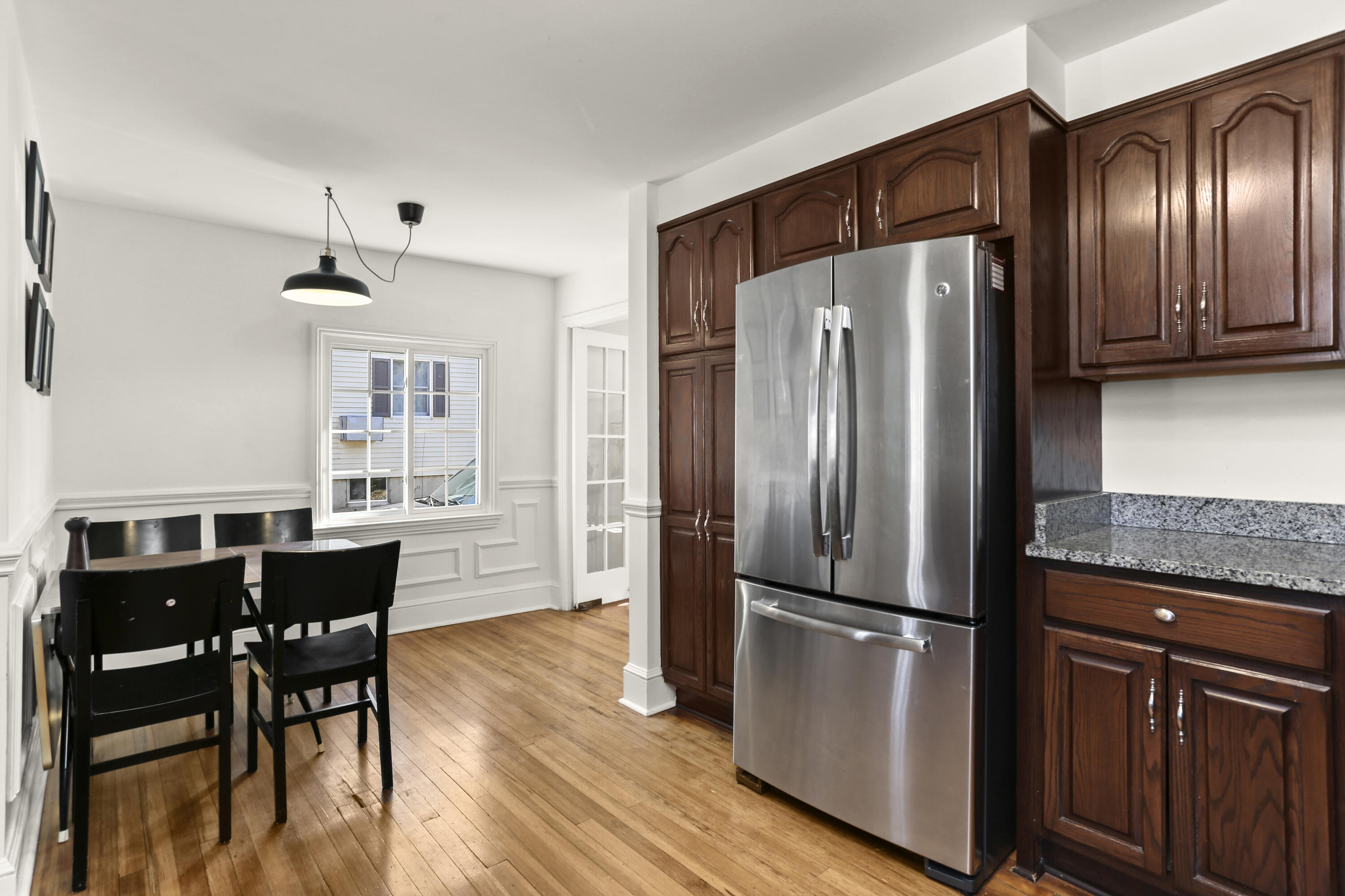 5 Hazel Street Norwalk, CT 06851 - Photo 14 of 32 a kitchen with stainless steel appliances granite countertop a refrigerator a stove a sink a dining table and chairs with wooden floor