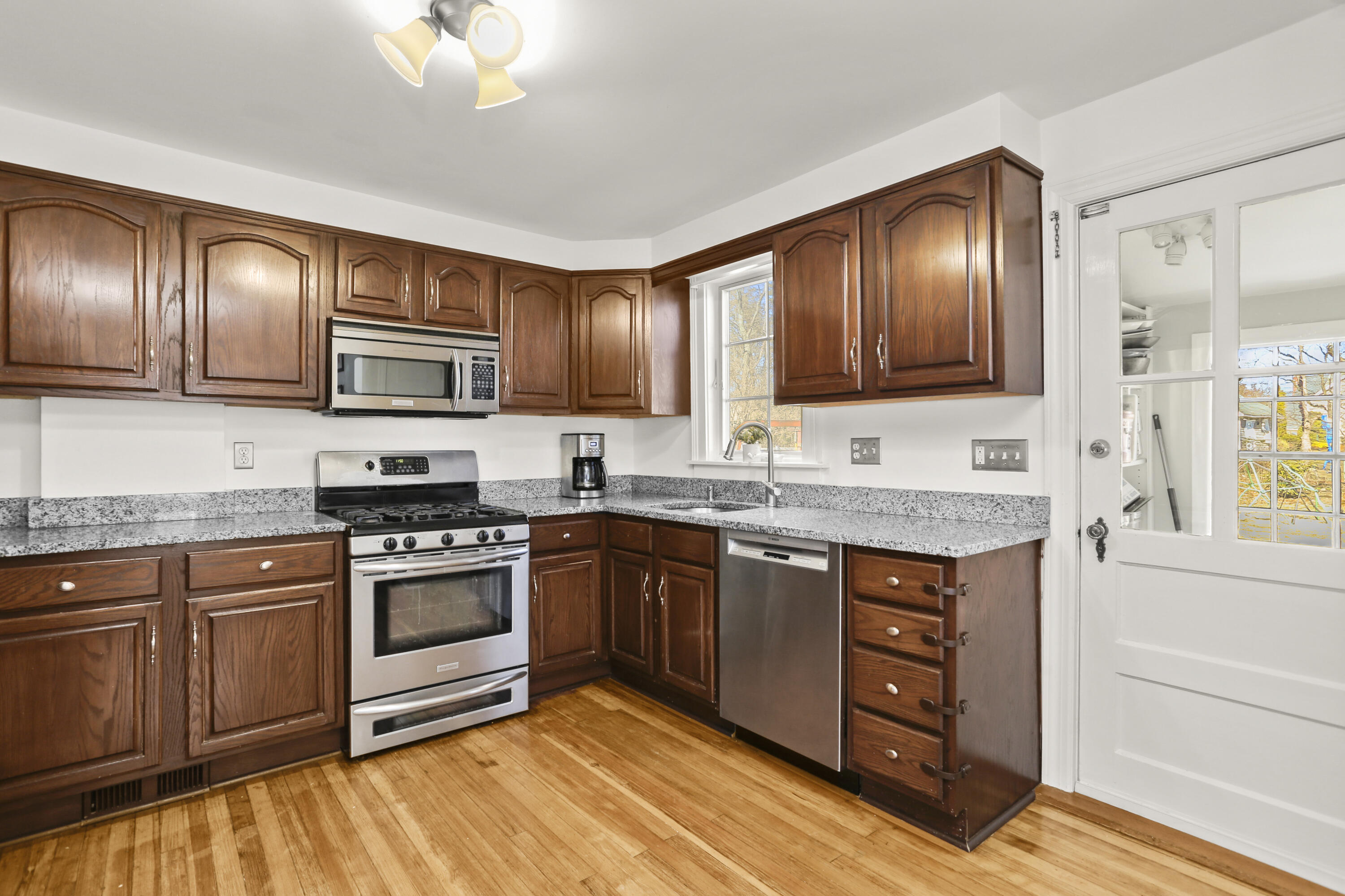 5 Hazel Street Norwalk, CT 06851 - Photo 16 of 32 a kitchen with granite countertop wooden cabinets a stove top oven and sink