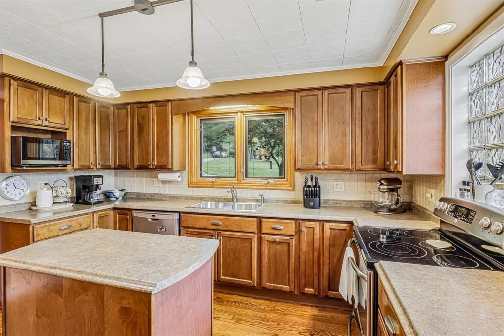 529 Utopia Road Apollo, PA 15613 - Photo 18 of 50 a kitchen with a stove a sink a refrigerator and wooden cabinets