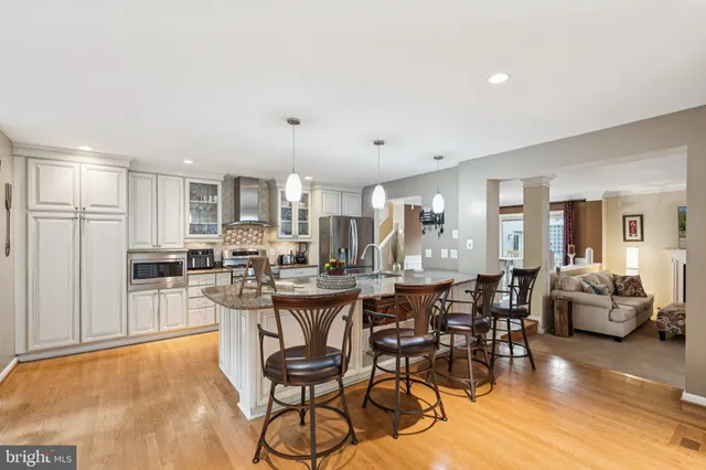 a view of a dining room and livingroom with furniture wooden floor a chandelier