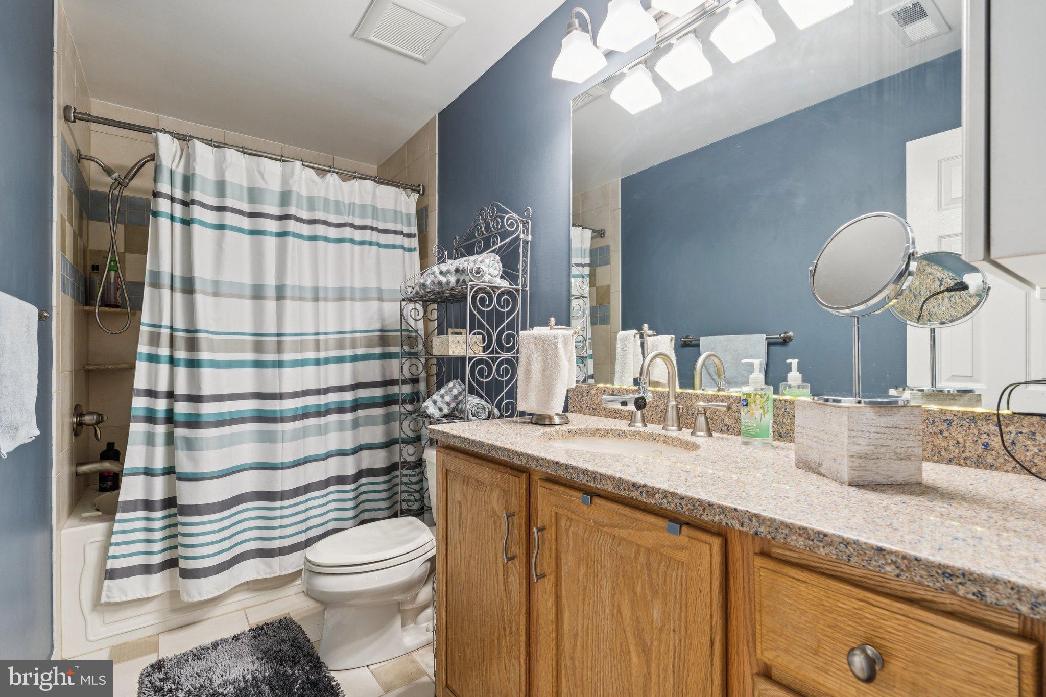47660 Pennrun Way Sterling, VA 20165 - Photo 14 of 55 a bathroom with a granite countertop toilet sink mirror and shower