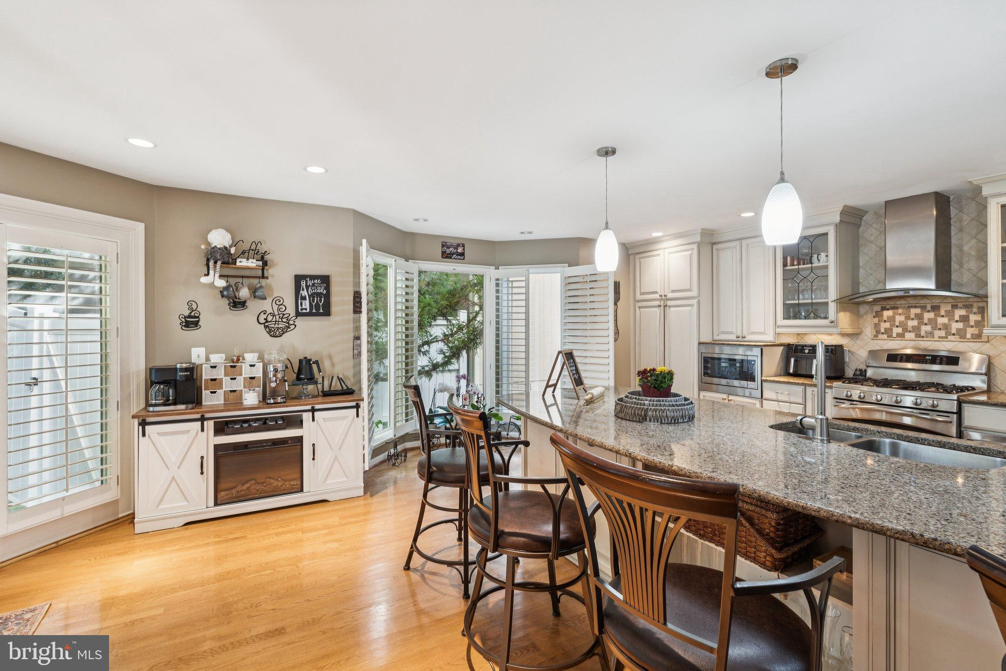 47660 Pennrun Way Sterling, VA 20165 - Photo 42 of 55 a kitchen with stainless steel appliances kitchen island granite countertop a stove a sink and white cabinets with wooden floor