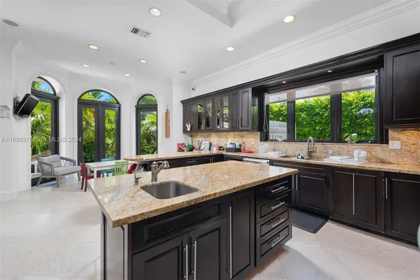 a kitchen with large windows and sink