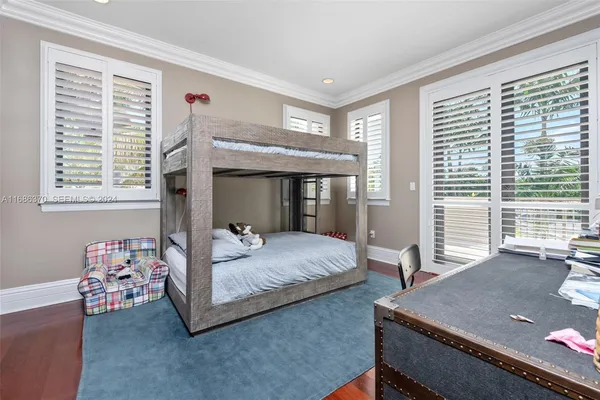 a bedroom with a bed and large windows