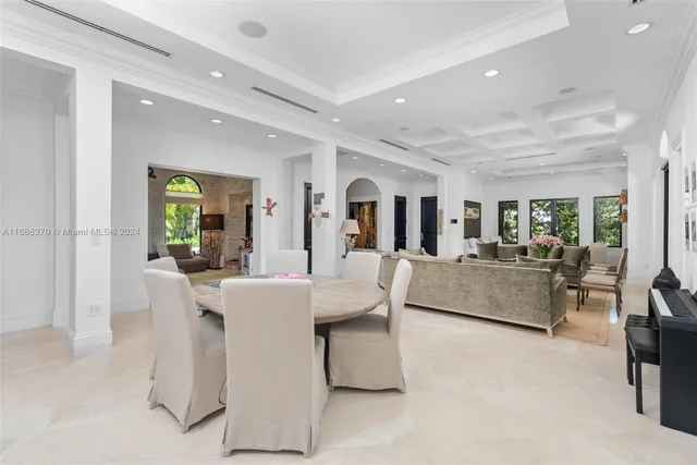 a living room with furniture and a dining table with kitchen view